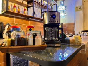 a counter with a coffee maker and jars on it at Hotel 305 in Parras de la Fuente