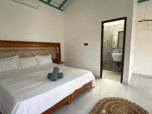 Un dormitorio con una cama con un animal de peluche encima. en ISOLA - Surf House, en Koggala