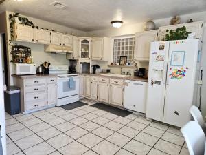 Una cocina con electrodomésticos y gabinetes blancos. en Harmony House Homestay, en Sedona