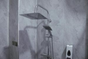 een douche met een douchekop in een badkamer bij Villa Alpaca in Accra +14 foto's