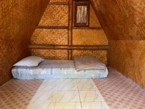 a small bed in a room with a wall at sleepy hut in Pai