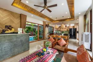 a living room with a ceiling fan and a kitchen at An Bang Sunset House in An Bàn (2)