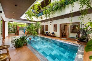 an indoor pool in a house with plants at An Bang Sunset House in An Bàn (2)