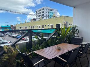a wooden table and chairs on a balcony at C You Rooms in Semporna