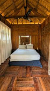 ein Schlafzimmer mit einem Bett in einem Holzzimmer in der Unterkunft NEW The Loft - Uluwatu Surf Ranch in Uluwatu