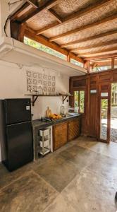 eine Küche mit einem schwarzen Kühlschrank und einem Herd in der Unterkunft NEW The Loft - Uluwatu Surf Ranch in Uluwatu + 2 Fotos