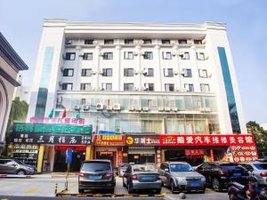 a large white building with cars parked in front of it at GreenTree Inn Express Hainan Haikou Haixiu Zhong Road in Haikou