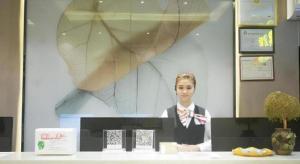 a woman is standing behind a counter in a room at GreenTree Inn Express Hainan Haikou Haixiu Zhong Road in Haikou