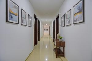 a hallway with paintings on the walls and a table at FabHotel Sri Sai in Pune