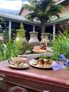 a table with two plates of food and cups on it at Glen Eden Lodge in Lidgetton
