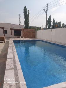 een groot zwembad met blauw water bij Villa Alpaca in Accra