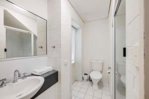 een witte badkamer met een wastafel en een toilet bij Shoreline Apartments - Unit 9b in Bargara