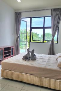 CC Regalia Homestay Kota Samarahan Kuching Sarawak في Kota Samarahan: سرير كبير في غرفة مع نافذة كبيرة