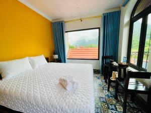a bedroom with a bed and a large window at Tam Coc Hope House in Ninh Binh
