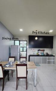 CC Regalia Homestay Kota Samarahan Kuching Sarawak في Kota Samarahan: مطبخ مع طاولة وكراسي وثلاجة