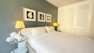 Un dormitorio con una gran cama blanca y dos lámparas. en Ausmine Sydney CBD 2Bedroom Apt, en Sídney