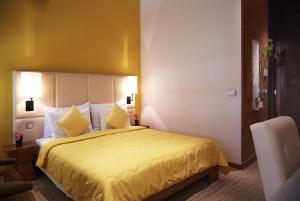 um quarto de hotel com uma cama com uma colcha amarela em ASTORIA Hotel Opatija em Opatija