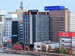 un edificio alto con señales en una ciudad en APA Hotel Oita Ekimae, en Oita