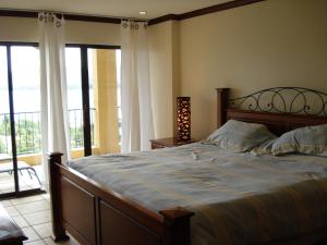 a bedroom with a large bed and a balcony at Sunset Heights 402 in Playa Flamingo