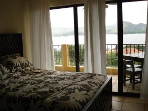 a bedroom with a bed and a balcony with a view at Sunset Heights 402 in Playa Flamingo