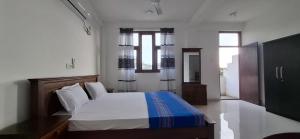 a bedroom with a bed with white sheets and a window at Bayview resort in Weligama