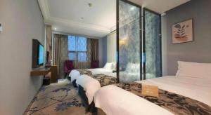 a hotel room with three beds and a television at Nanjing Grand Da Qiao Hotel in Nanjing