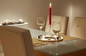a candle and two wine glasses on a table at ASTORIA Designhotel Opatija in Opatija