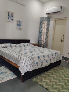 a bedroom with a bed with a comforter on it at Virudravilla in Jodhpur