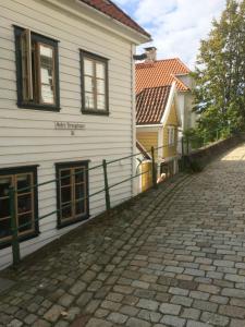 a cobblestone street in front of a white building at Annehelenes B&B in Bergen +9 photos