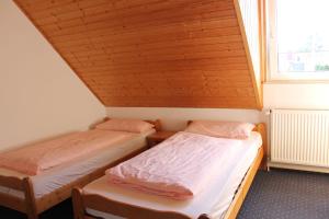 two beds in a small room with a window at GLÜCKSHAUS Ferienwohnung in Cuxhaven