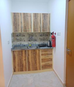 شقق مفروشة العين النود في العين: مطبخ مع خزائن خشبية ومغسلة +5 صور