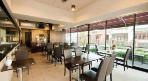 un restaurante con mesas, sillas y ventanas en Wsotel Hotel, en Ban Khao Rup Chang