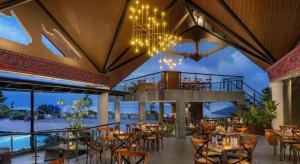 Un restaurante con mesas y sillas y un balcón. en Hotel Niagara Parapat, en Parapat