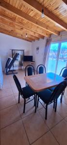 Un comedor con una mesa y sillas y un piano. en Reloj, en Malargüe