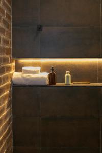 Baño con estante con toallas y lavamanos en The Libreville Boutique Hotel, en Abuja