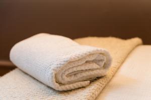 a white towel sitting on top of a bed at Lovely 2 Rooms Next to Sint-Niklaas Very Central in Ghent