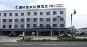 GreenTree Inn Qingdao Jiaozhou Jiaoping Road Express Hotel في Jiaoxian: مبنى أبيض كبير عليه لافتة