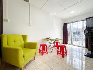 #SE Cozy&Warm 3Bedroom HomeStay 10PAX by S&T Homez في سِريمبان: غرفة معيشة فيها كرسي اصفر وطاولة
