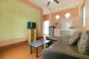 a living room with a couch and a tv at OYO 949 Sansuk Resort Paknampran in Pran Buri