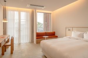 콘스트호텔 في Hyŏpchae-ri: غرفة نوم بها سرير وأريكة ونافذة