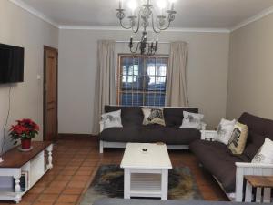 a living room with a couch and a table at Mountain Zebra Cottage in Graaff-Reinet