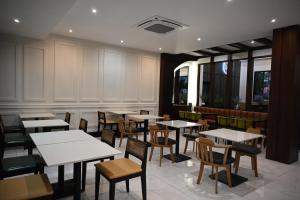 Ban Pho TouaneRS1 Hotel的摆放着白色桌椅的餐厅