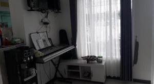 a piano sitting in a room with a window at OYO Life 91323 Omah Victoria Homestay & Culinary in Tempuran