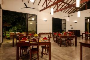 丹不拉Arika Villa - Special Deals on F&B and Spa Treatments的配有木桌椅的餐厅