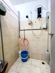 #SE Cozy&Warm 3Bedroom HomeStay 10PAX by S&T Homez في سِريمبان: دش مع دلو أزرق في الحمام