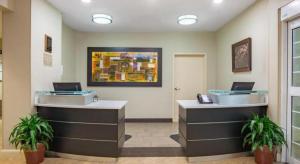 Candlewood Suites Jefferson City By IHG في Apache Flats: لوبي فيه مكتبين استقبال وعليهم لابتوب
