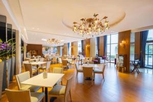 a restaurant with tables and chairs and a chandelier at Xian Grand Noble Hotel in Xi'an