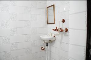 Un baño con un lavabo y un espejo en la pared. en Shree Bihari ji Dham, en Vrindāvan