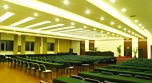 a large room with chairs and tables and plants at New Friendship Hotel in Luoyang