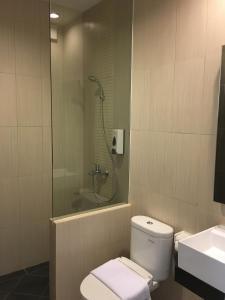 een badkamer met een douche, een toilet en een wastafel bij MSquare Palembang in Palembang